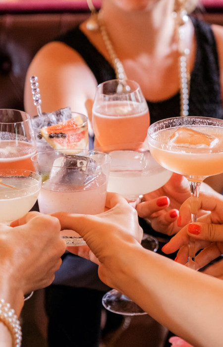 Group of people holding their drinks out to say cheers